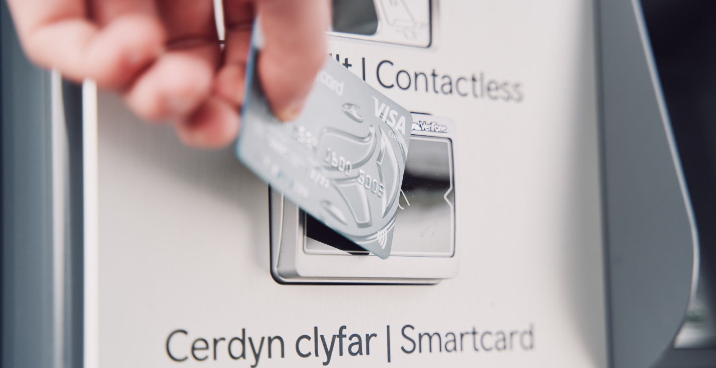 A passenger using a contactless card to pay at a TfW self service ticket machine