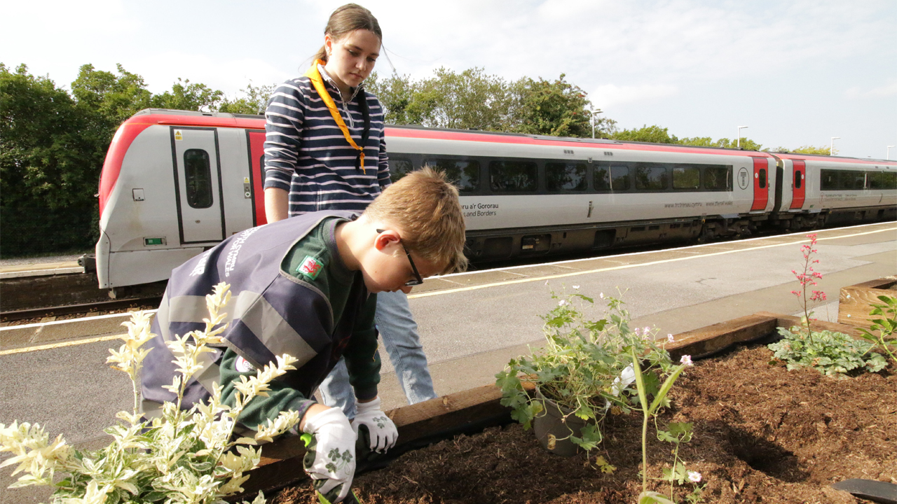 Scouts planting flowers at Kidwelly railway station