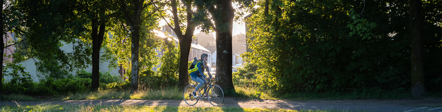 Woman cycling through a forest area