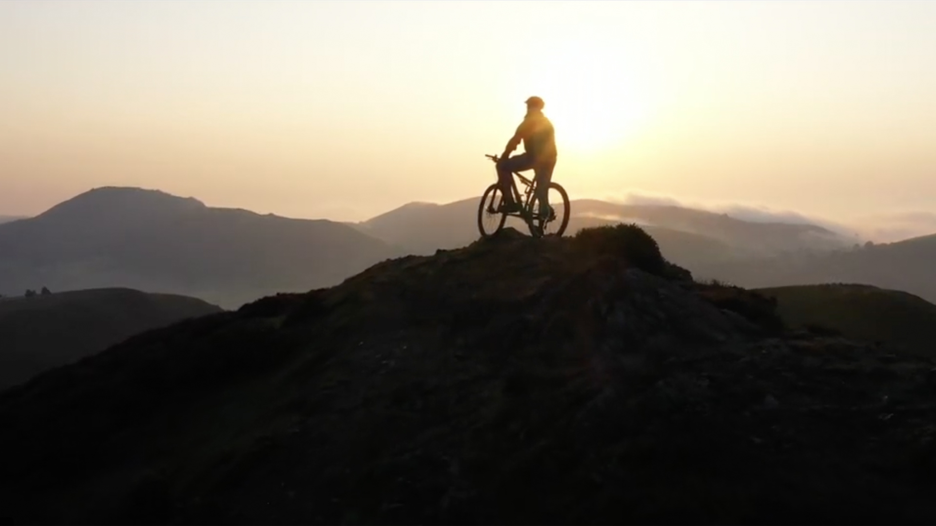 A person on a bicycle at the top of a hillside