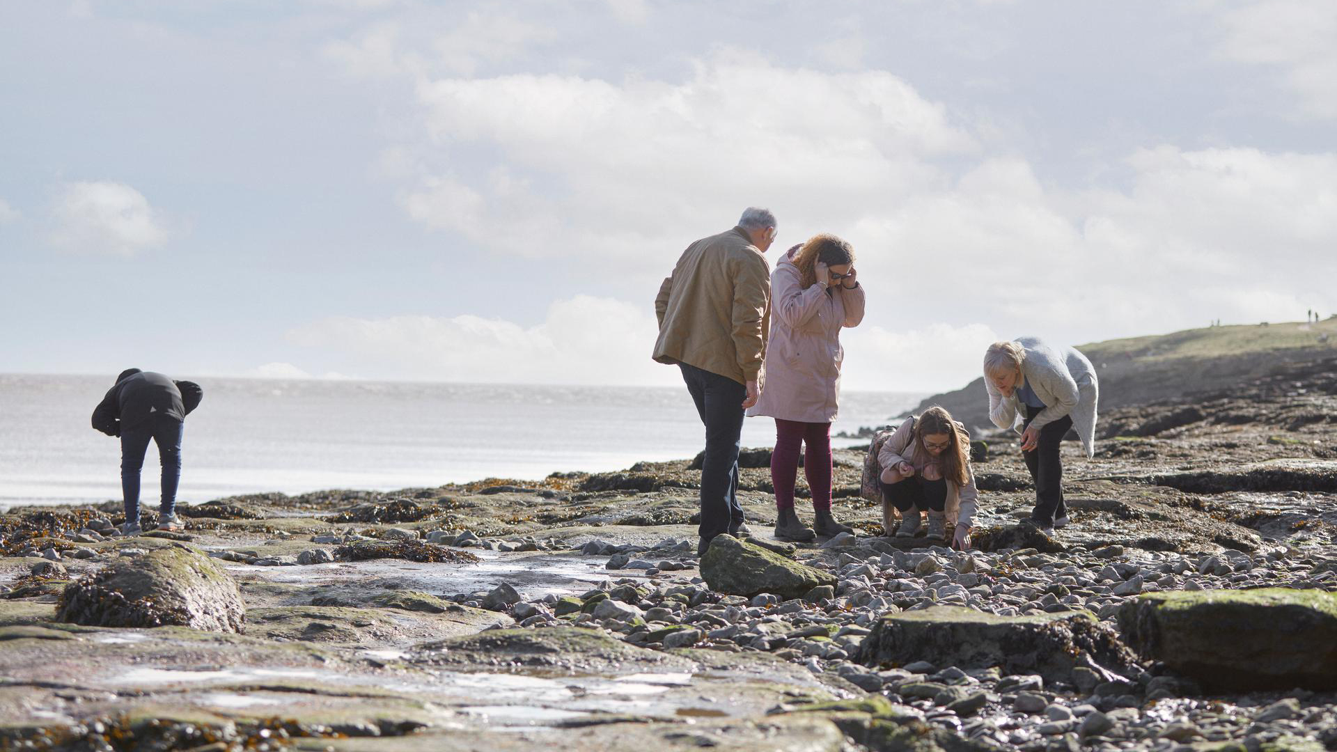 Family looking at rocks on a beach 
