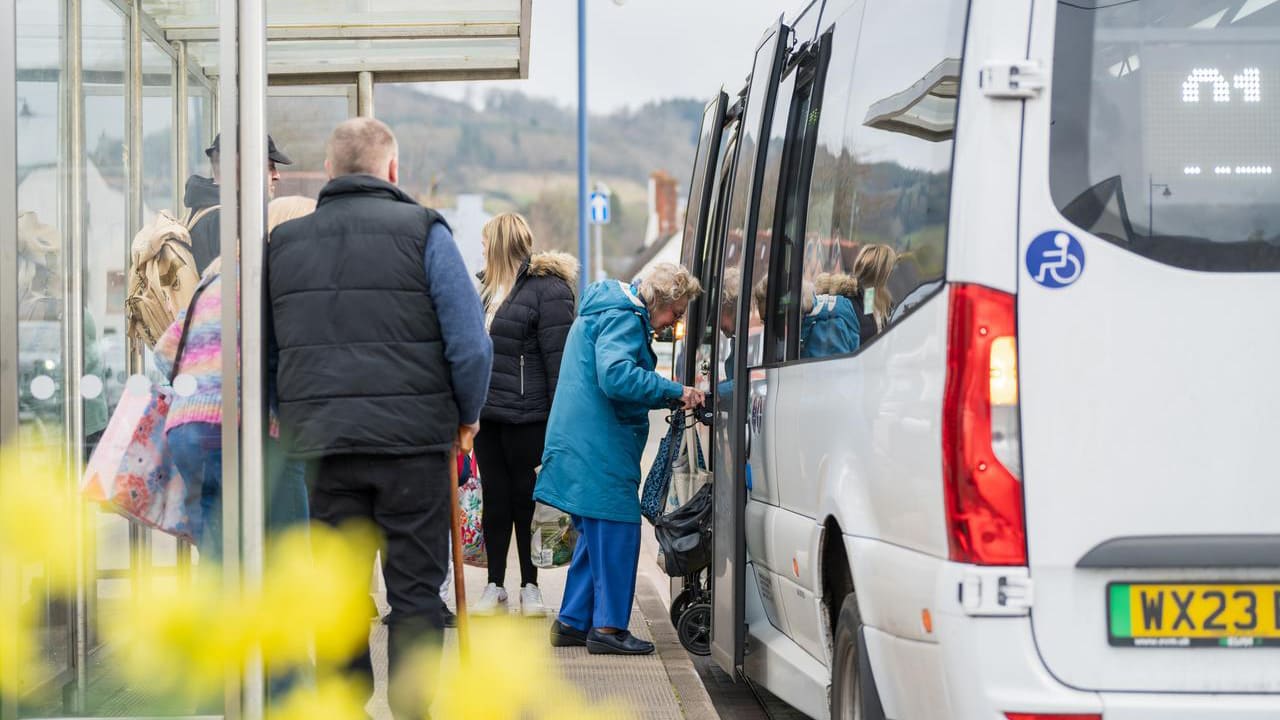 Older person boarding a fflecsi bus