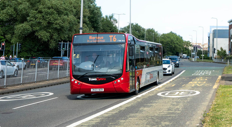 A TrawsCymru service driving down a road in Swansea