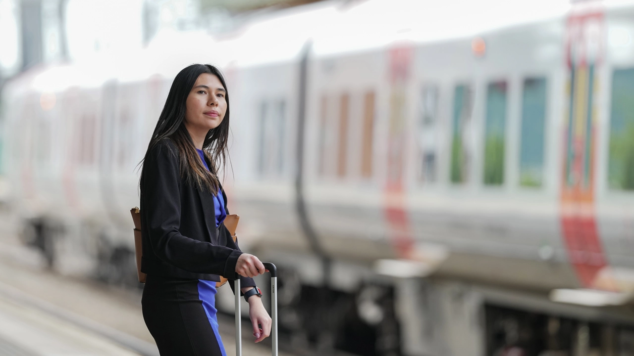A person with a suitcase waiting for a train