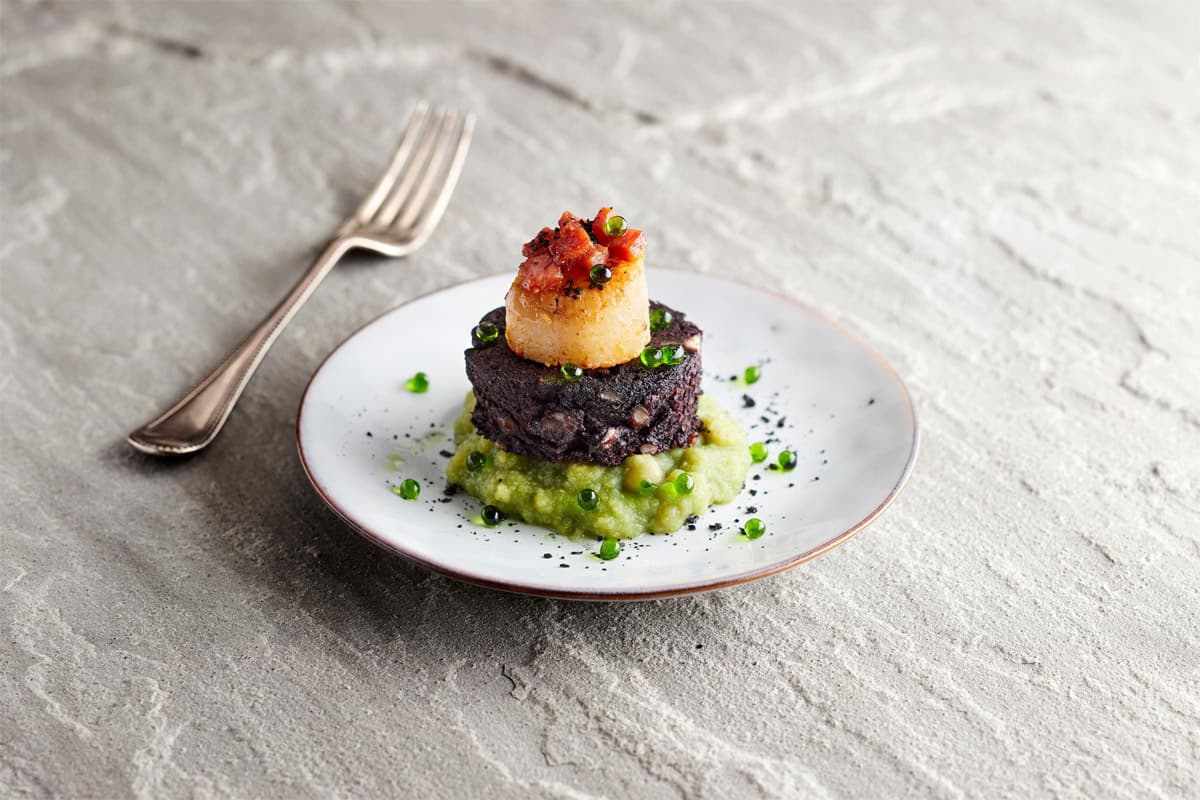 Scallop on a plate with a fork on the side